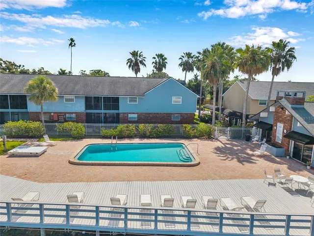 a view of house with swimming pool and tall trees