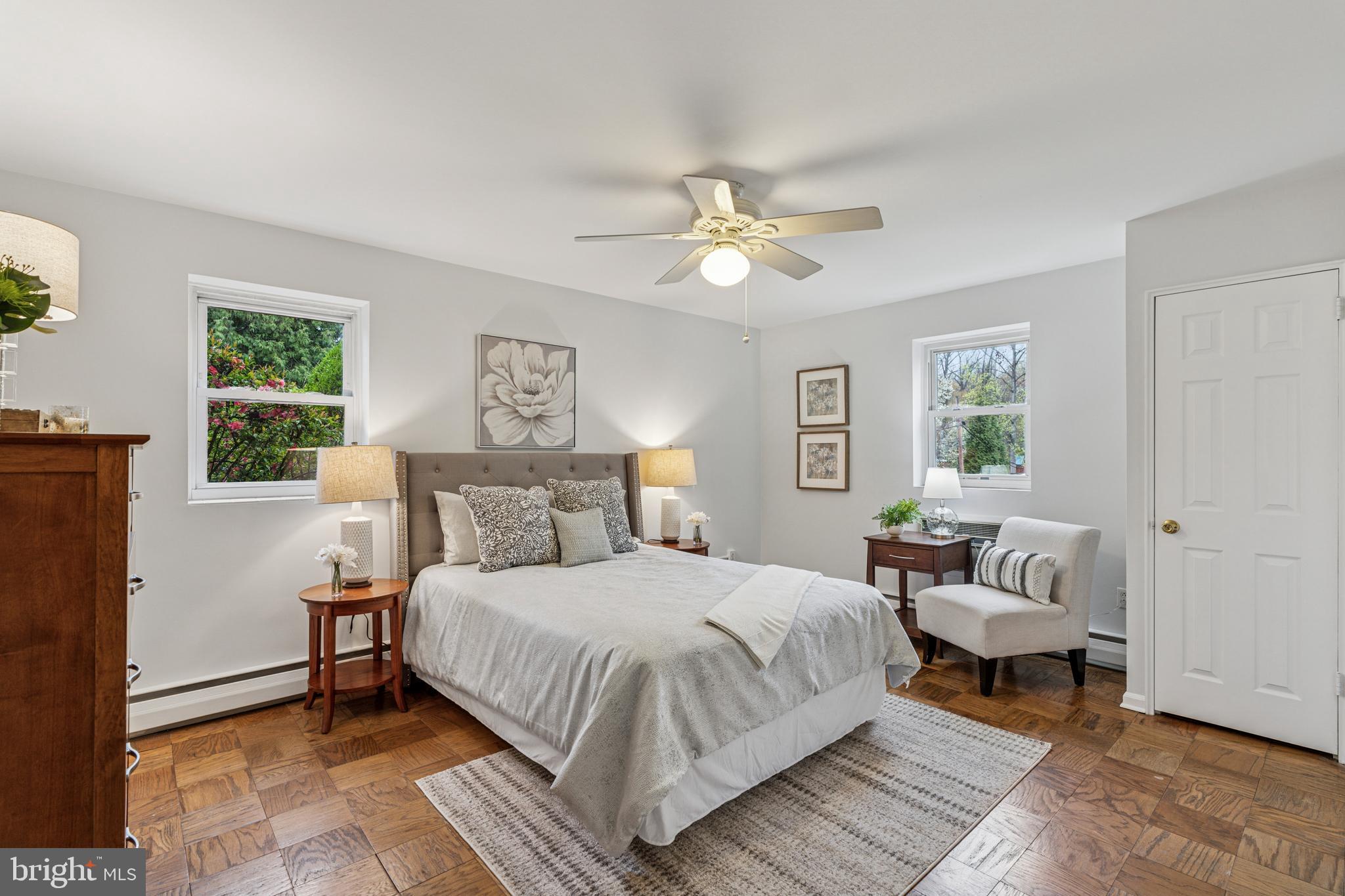 412 North Wayne Avenue, Unit 108 Wayne, PA 19087 - Photo 11 of 17 a bedroom with a large bed a chandelier and windows