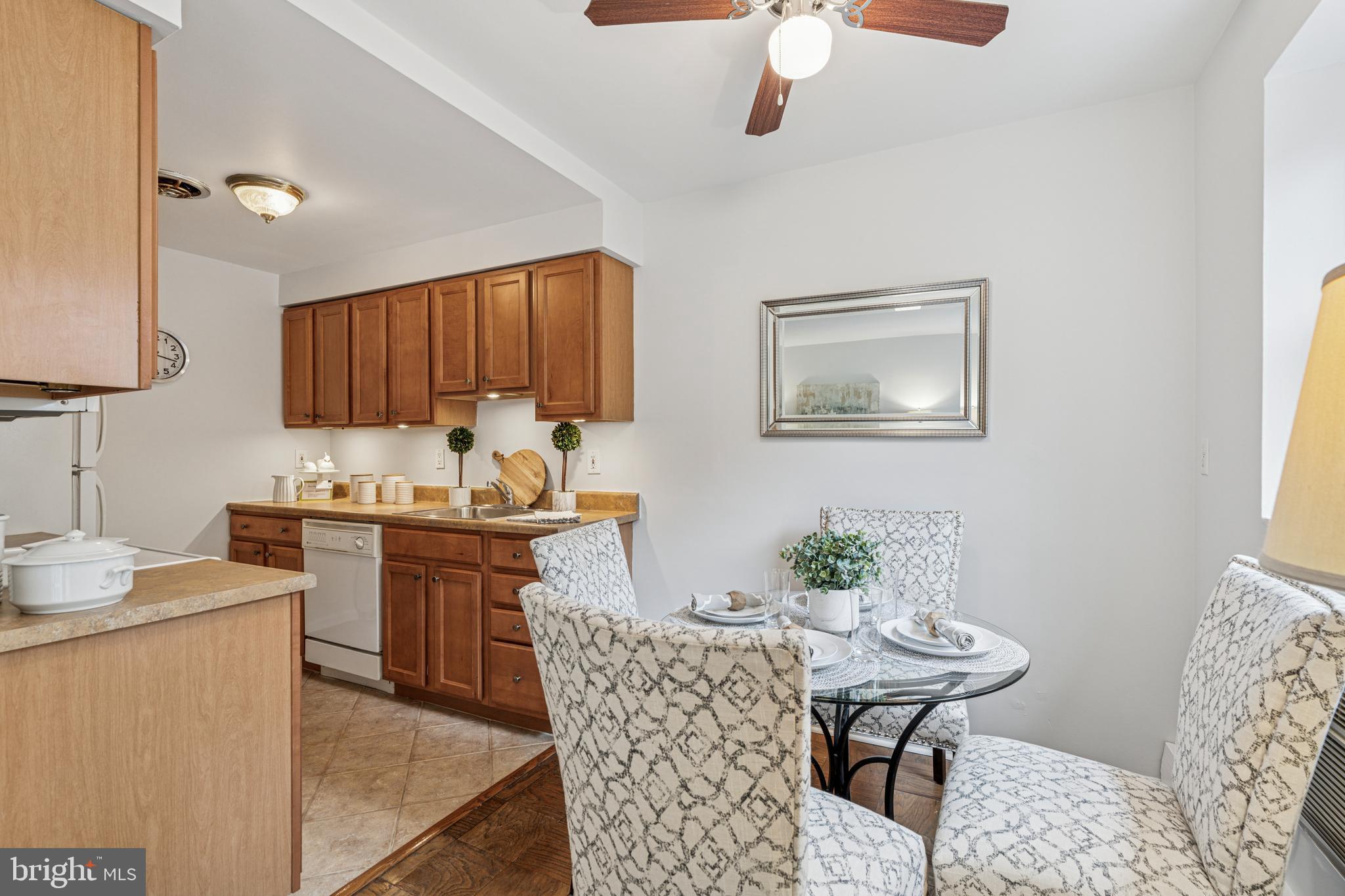 412 North Wayne Avenue, Unit 108 Wayne, PA 19087 - Photo 7 of 17 a kitchen with stainless steel appliances granite countertop a stove a sink a dining table and chairs with wooden floor