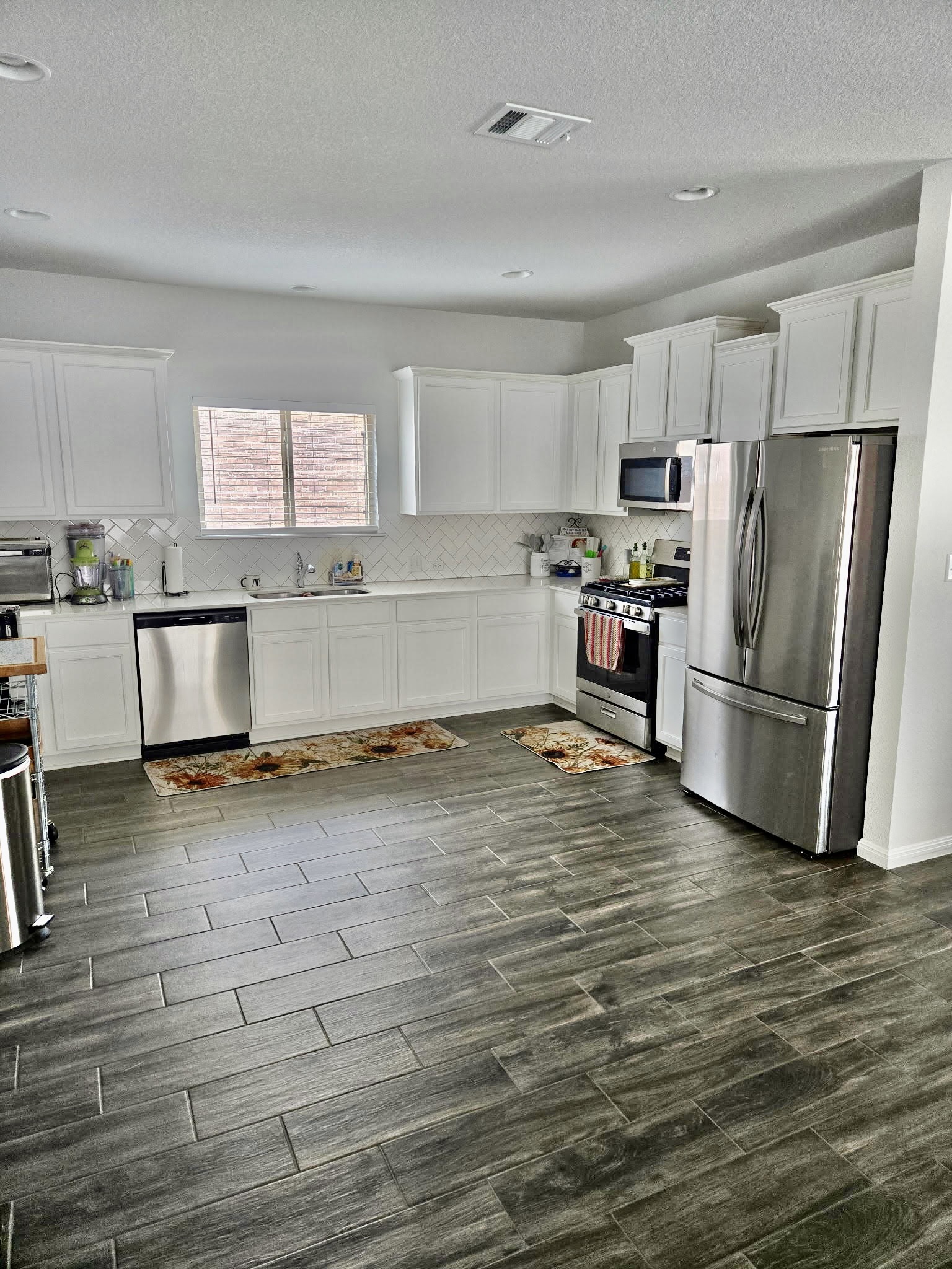 140 Pentro Path Georgetown, TX 78626 - Photo 5 of 37 Bright and airy kitchen features modern white cabinetry and sleek stainless steel appliances.