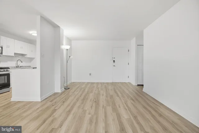 a view of a kitchen with wooden floor and white kitchen