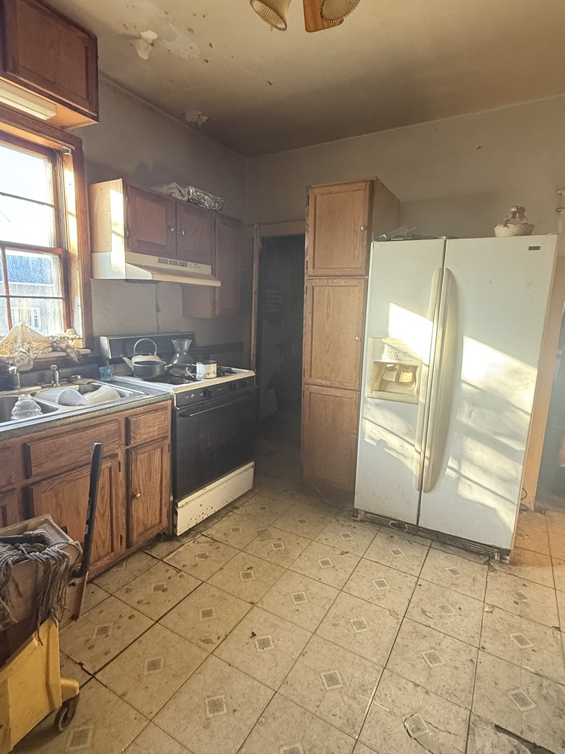 445 155th Place Calumet City, IL 60409 - Photo 9 of 14 a kitchen with stainless steel appliances a sink a stove a refrigerator and cabinets