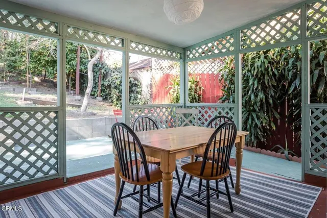 a view of a dining room with furniture large windows and wooden floor