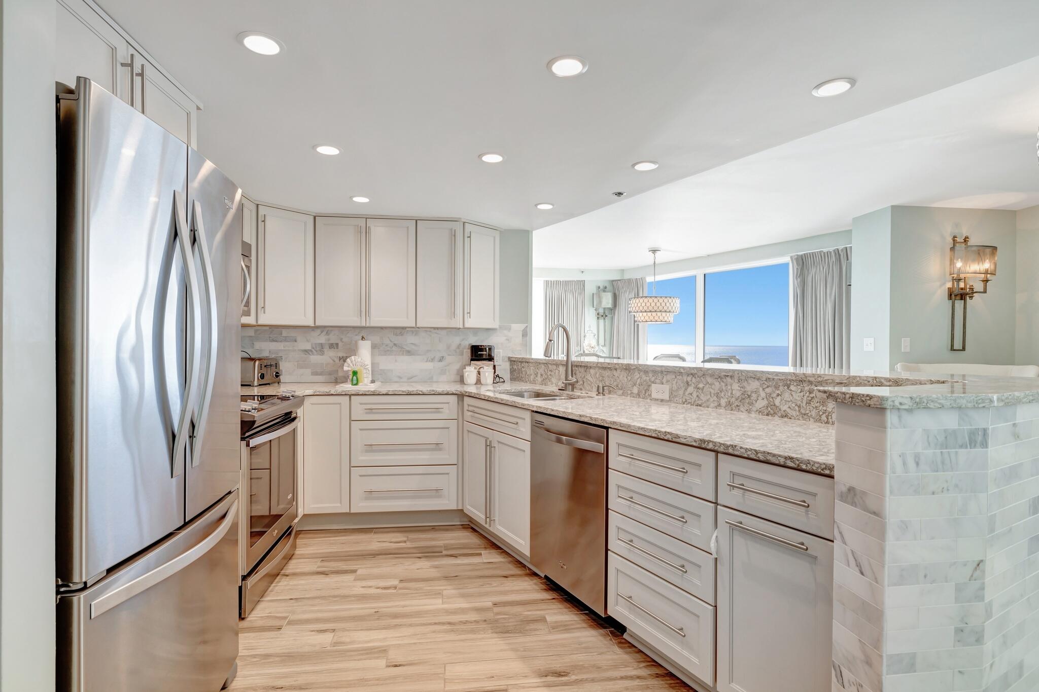 4323 Beachside 2, Unit 323 Miramar Beach, FL 32550 - Photo 5 of 41 a kitchen with white cabinets stainless steel appliances and a island