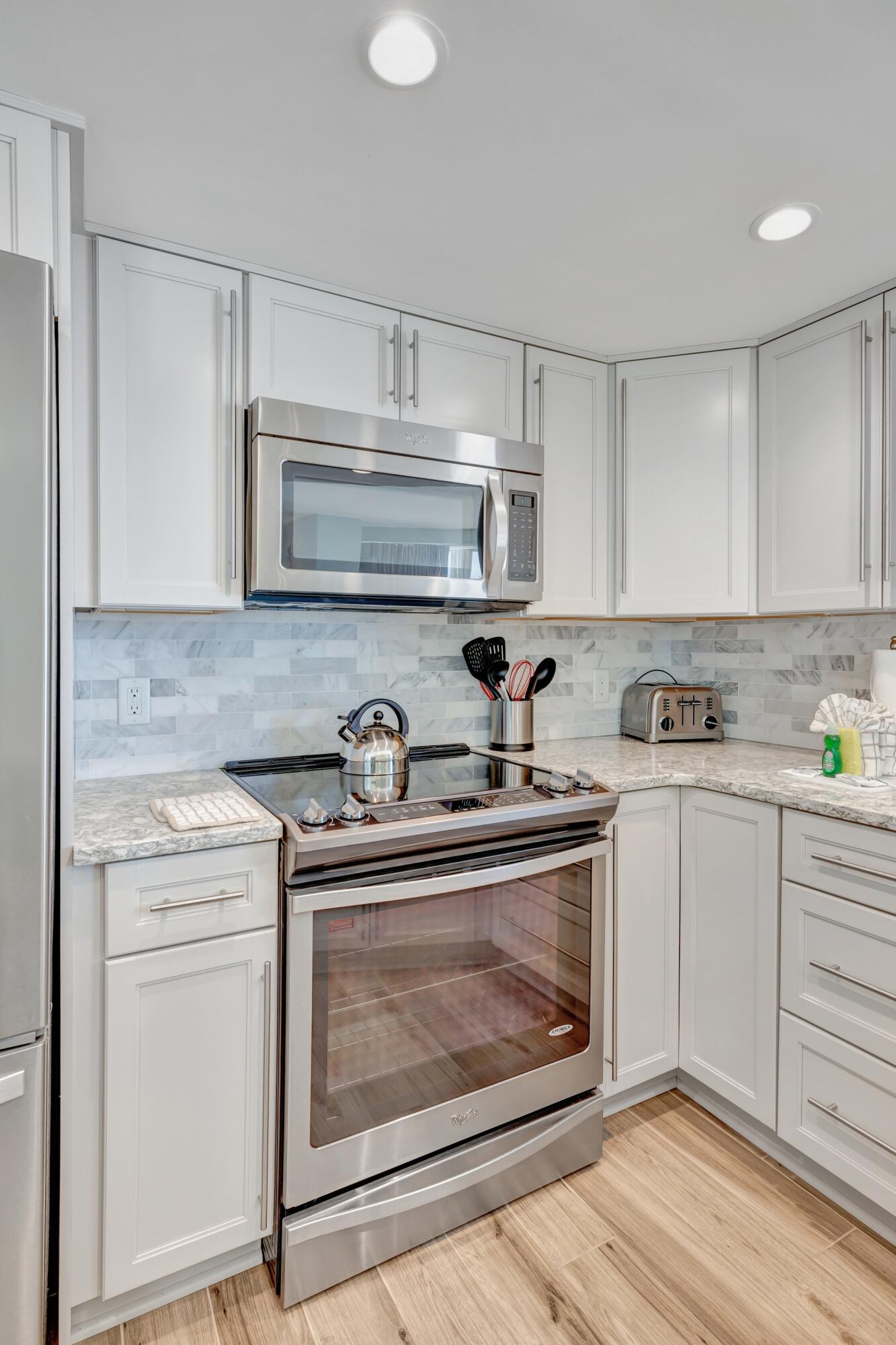 4323 Beachside 2, Unit 323 Miramar Beach, FL 32550 - Photo 6 of 41 a kitchen with stainless steel appliances granite countertop a stove and white cabinets