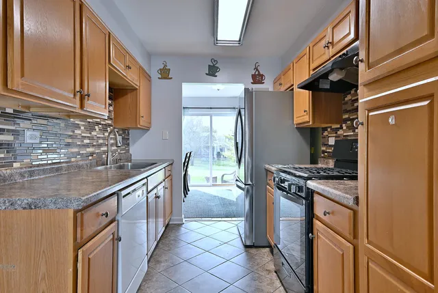 a kitchen with stainless steel appliances granite countertop a stove a sink and a refrigerator