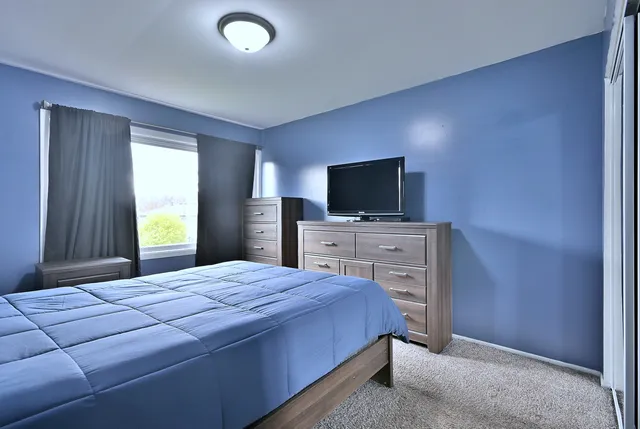 a bedroom with a bed and a flat screen tv