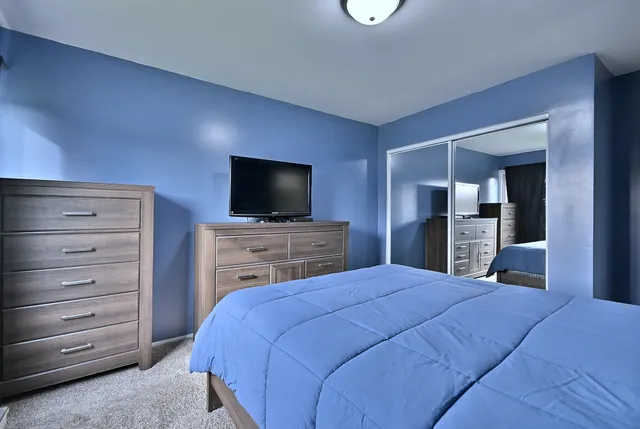 a bedroom with a bed and a flat screen tv