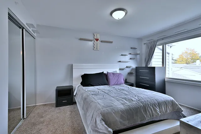 a bedroom with a bed and a large window