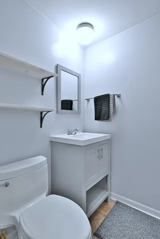 a bathroom with a toilet sink and mirror