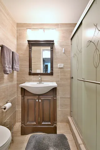 a bathroom with a sink a toilet and shower