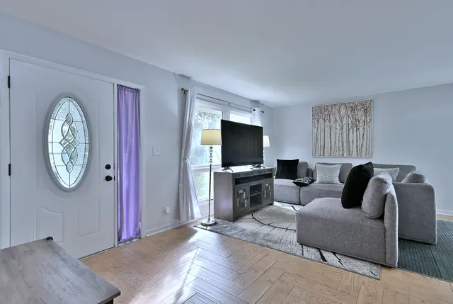 a living room with furniture a window and a flat screen tv