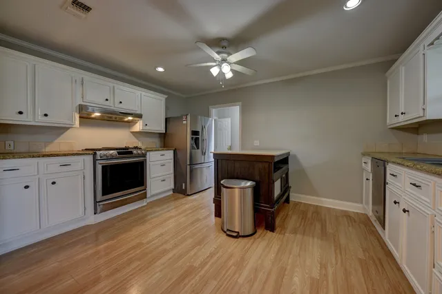 a kitchen with cabinets and wooden floor