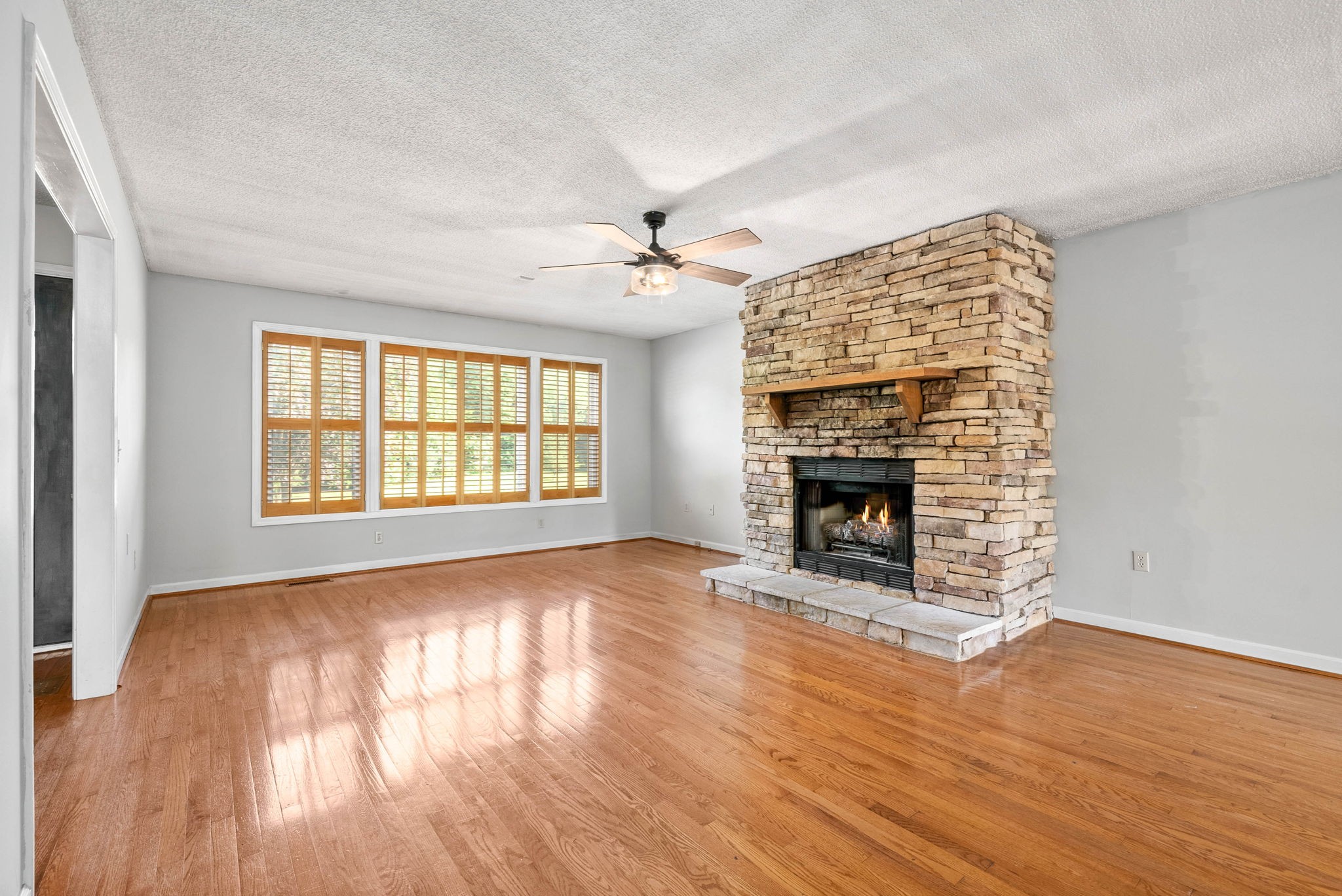 2946 Old Clarksville Springfield Road Adams, TN 37010 - Photo 6 of 45 wooden floor fireplace and windows in an empty room