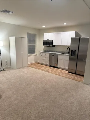 a spacious bedroom with a bed a desk and chair