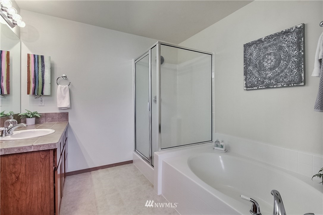 3104 Walker Road DuPont, WA 98327 - Photo 15 of 25 a bathroom with a tub sink and mirror