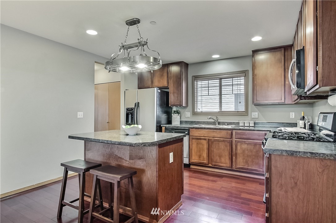 3104 Walker Road DuPont, WA 98327 - Photo 6 of 25 a kitchen with kitchen island granite countertop a sink a counter space appliances and cabinets
