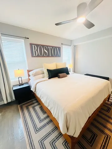 a bedroom with a bed and a flat tv screen on dresser