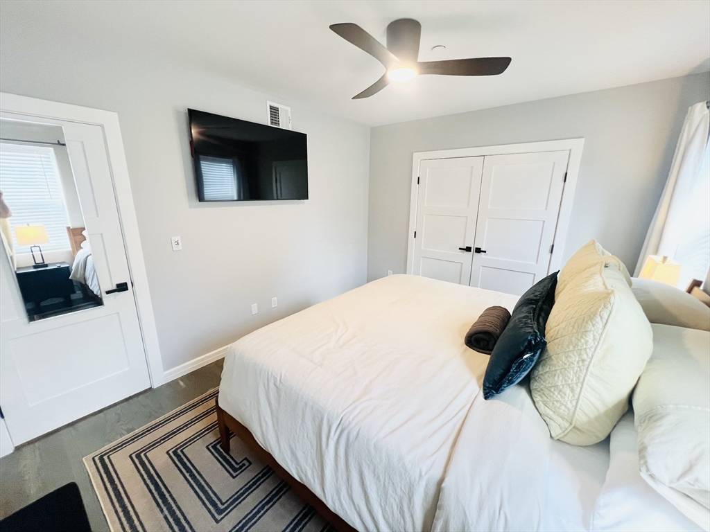 47-49 Walnut Street, Unit 1R Boston, MA 02122 - Photo 13 of 13 a bedroom with a bed and a flat tv screen on dresser