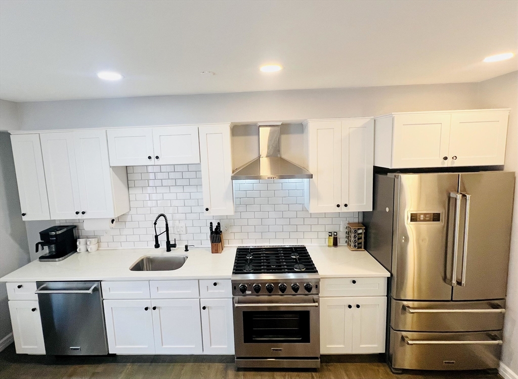 47-49 Walnut Street, Unit 1R Boston, MA 02122 - Photo 4 of 13 a kitchen with a sink a refrigerator and cabinets