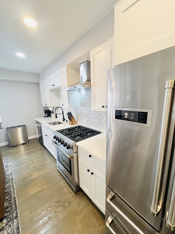 47-49 Walnut Street, Unit 1R Boston, MA 02122 - Photo 5 of 13 a kitchen with stainless steel appliances granite countertop a stove a refrigerator and a sink