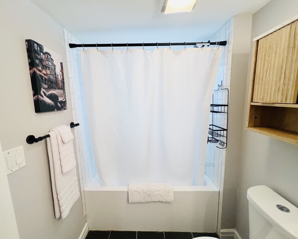 47-49 Walnut Street, Unit 1R Boston, MA 02122 - Photo 9 of 13 a bathroom with a shower and a tub