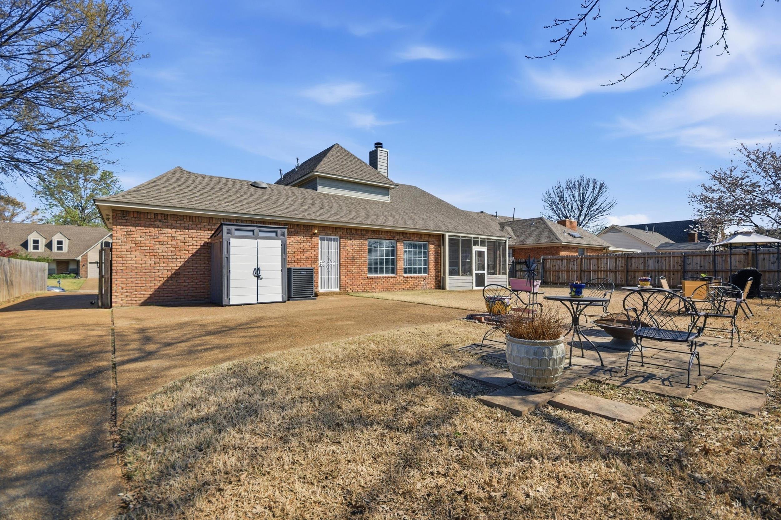 6605 Stephan Ridge Cove Bartlett, TN 38135 - Photo 29 of 30 Rear view of house featuring a patio area, a fenced backyard, brick siding, a shingled roof, and a chimney