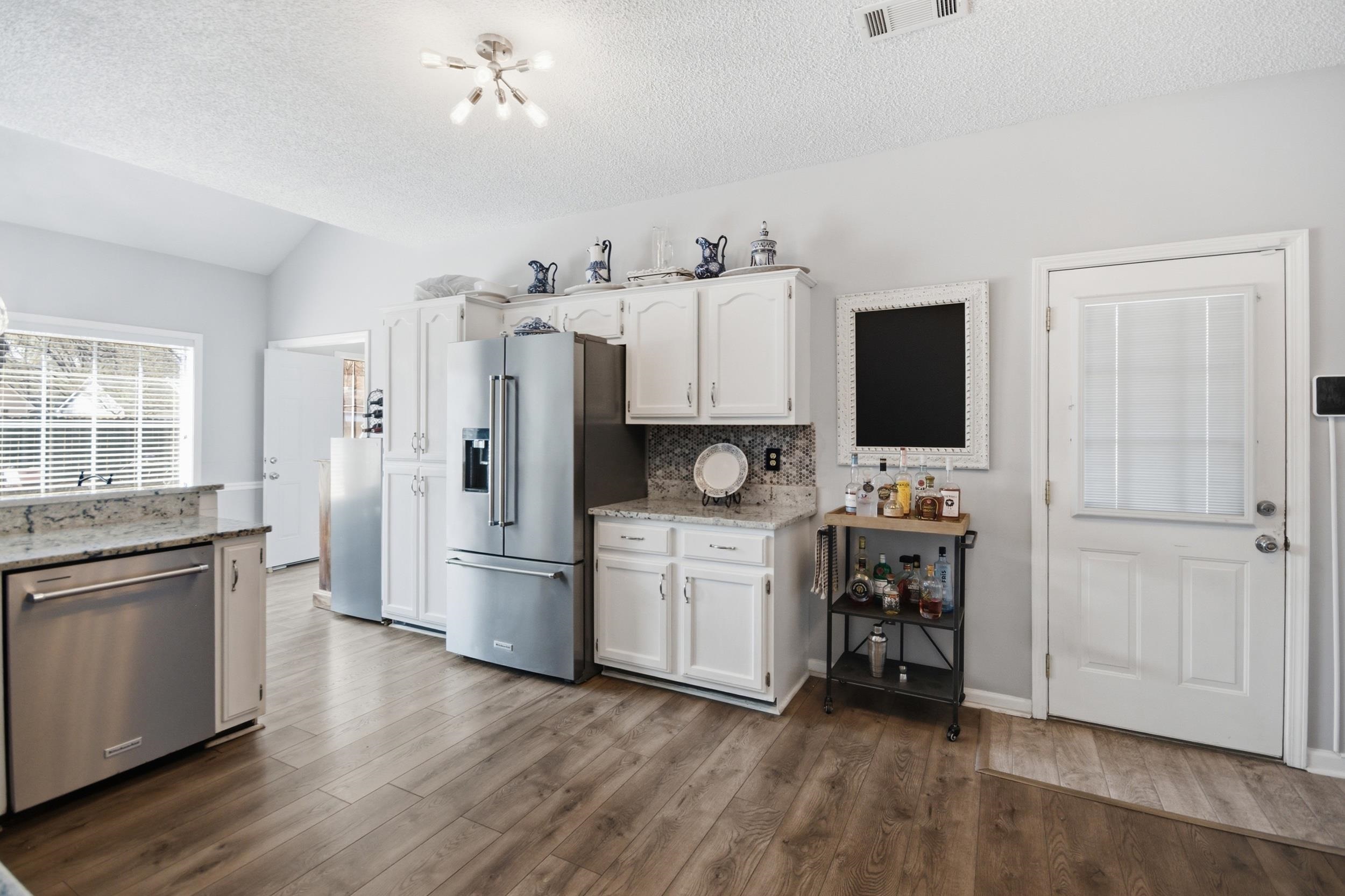 6605 Stephan Ridge Cove Bartlett, TN 38135 - Photo 5 of 30 Kitchen with white cabinetry, stainless steel appliances, and light stone counters