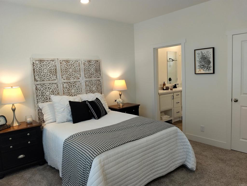 718 Sycamore Avenue, Unit 170 Vista, CA 92083 - Photo 13 of 22 a bedroom with a bed and a lamp