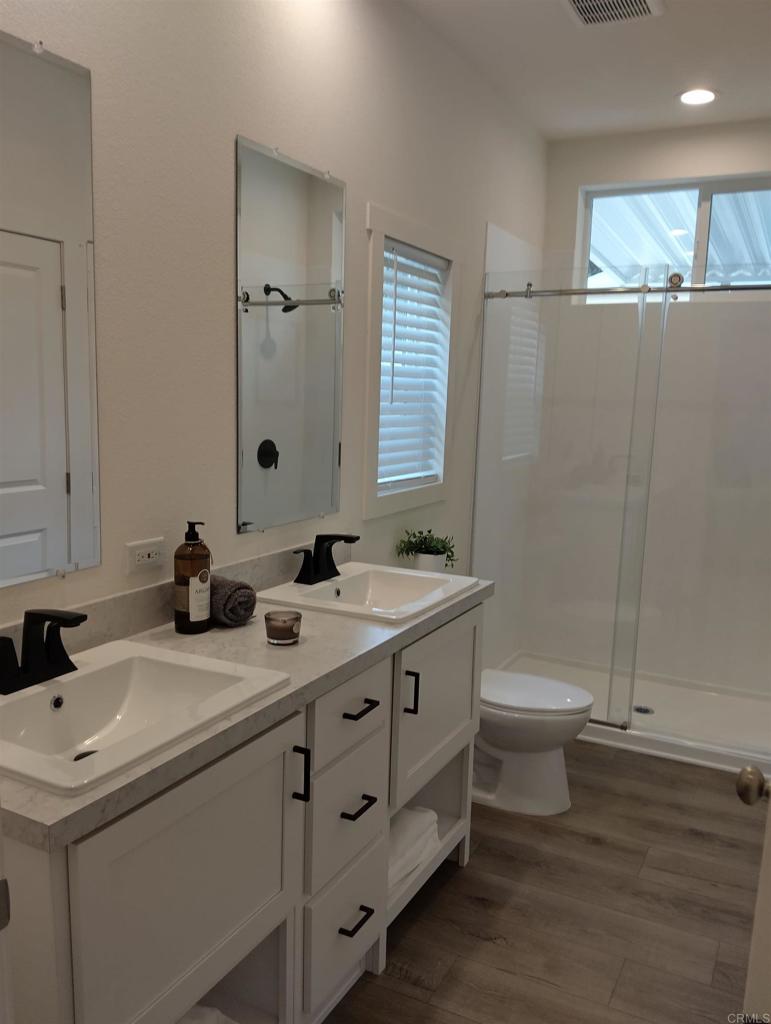 718 Sycamore Avenue, Unit 170 Vista, CA 92083 - Photo 16 of 22 a bathroom with a double vanity sink toilet and shower