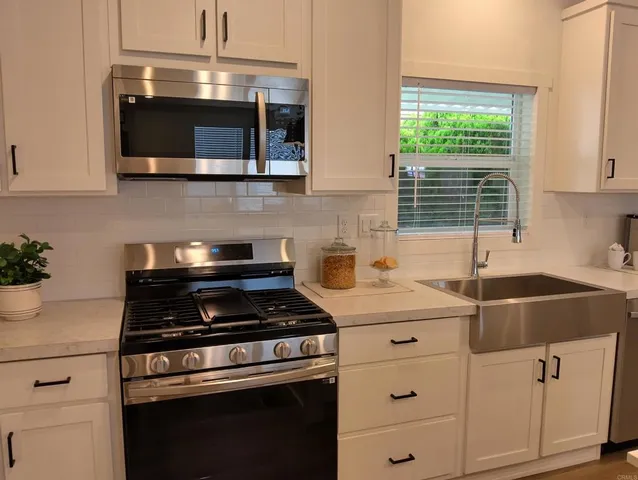 a kitchen with cabinets stainless steel appliances and a sink