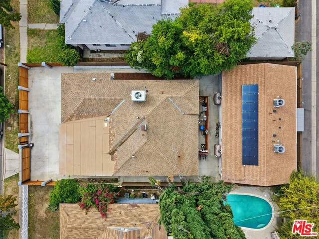 an aerial view of a house with outdoor space and seating area