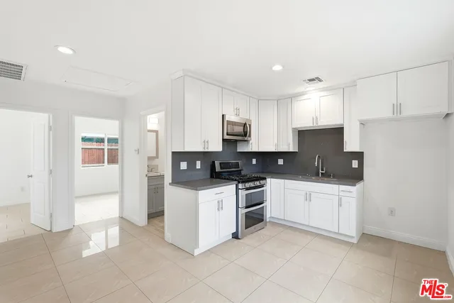 a kitchen with stainless steel appliances a refrigerator sink and cabinets