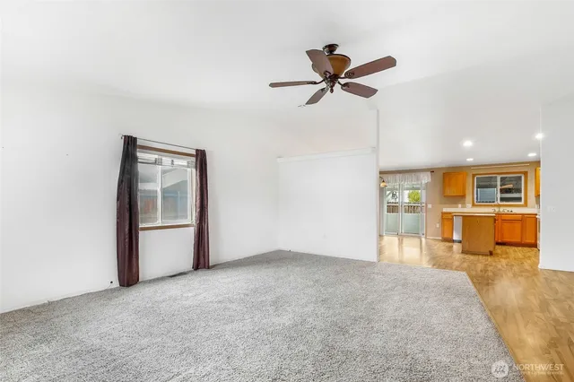 a view of a big room with windows and chandelier fan