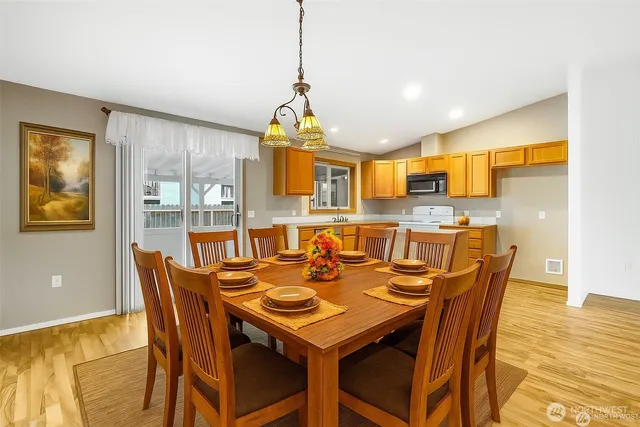 a kitchen with stainless steel appliances granite countertop a sink a stove a refrigerator cabinets and living room view