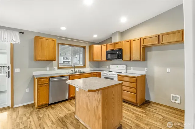 a kitchen with stainless steel appliances granite countertop a sink stove and refrigerator