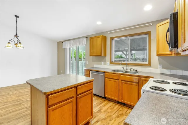 a kitchen with stainless steel appliances granite countertop a sink stove and cabinets