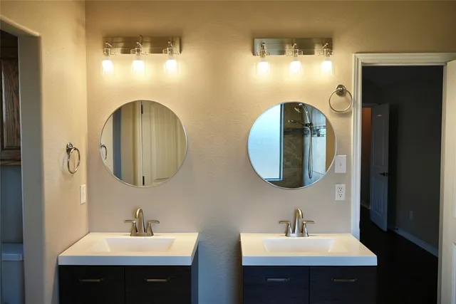 a bathroom with double vanity sinks and a mirror