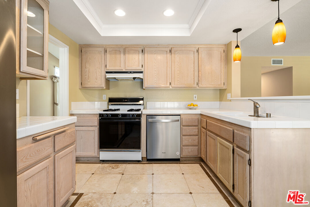 27050 Riversbridge Way Valencia, CA 91354 - Photo 4 of 37 a kitchen with a sink stove and refrigerator