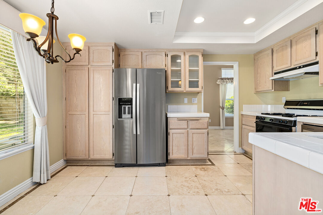 27050 Riversbridge Way Valencia, CA 91354 - Photo 5 of 37 a kitchen with stainless steel appliances a refrigerator and a stove top oven
