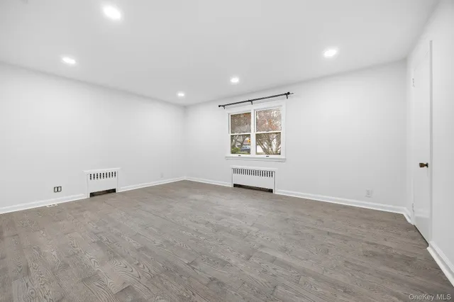 a view of a hallway with wooden floor and entryway