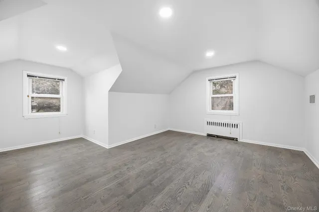 an empty room with windows and refrigerator