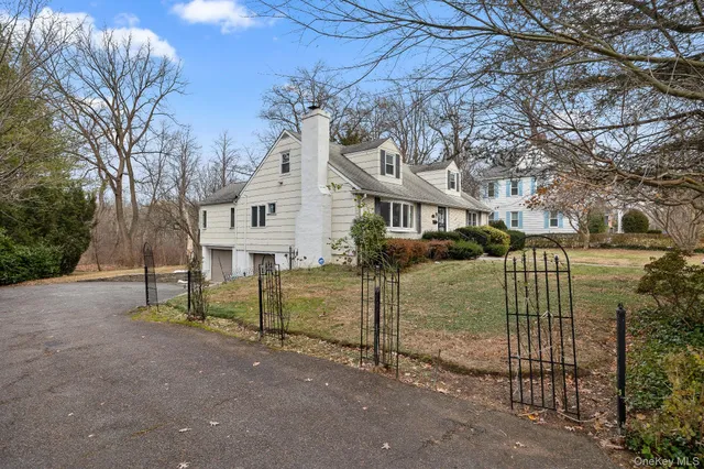 a view of a white house with a large tree and a yard