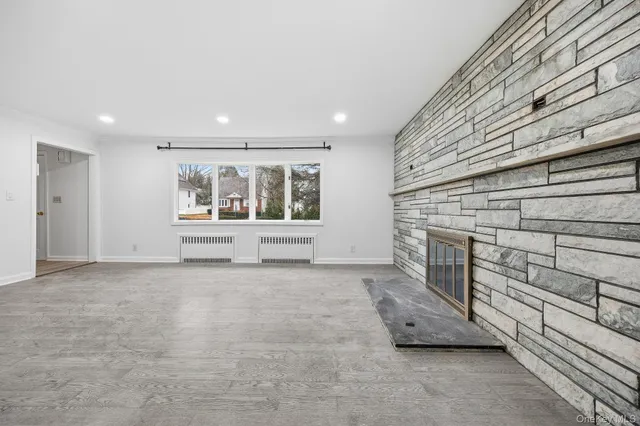 a view of an empty room with a fireplace and a window