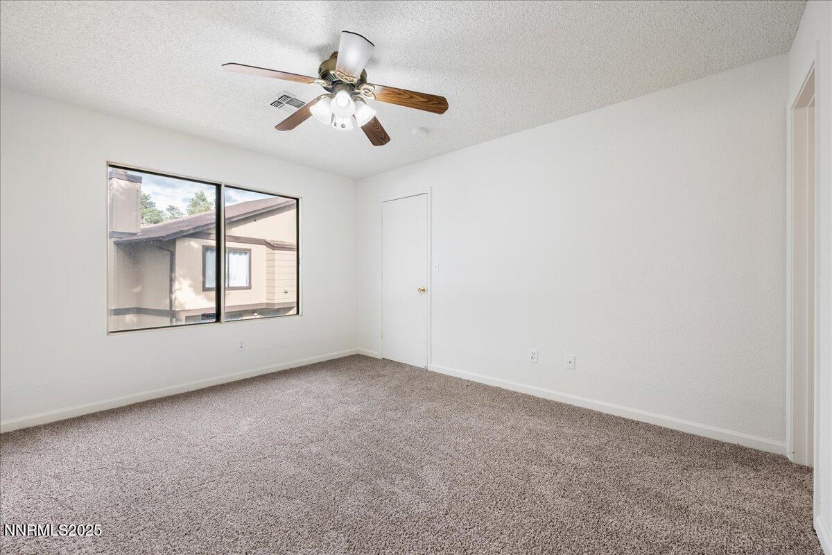 4418 Matich Drive Reno, NV 89502 - Photo 15 of 37 an empty room with windows and chandelier fan