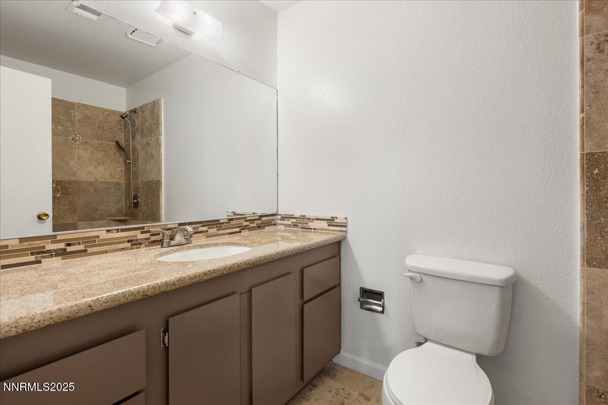 4418 Matich Drive Reno, NV 89502 - Photo 17 of 37 a bathroom with a granite countertop toilet sink and mirror