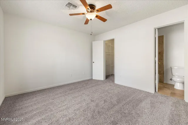 an empty room with a ceiling fan and a window