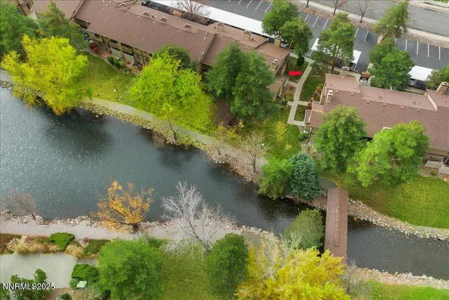 an aerial view of a house with a yard and lake view