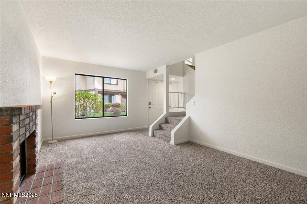 4418 Matich Drive Reno, NV 89502 - Photo 5 of 37 a view of an empty room with a fireplace and a window