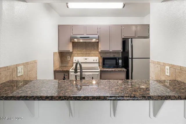 a kitchen with kitchen island a counter top space a sink stainless steel appliances and a counter top space